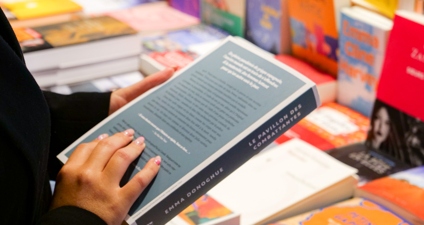 Étudiante consultant un livre au rayon de la librairie